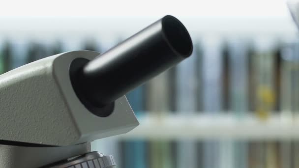 Mannelijke wetenschapper regelt Microscoop voor het bestuderen van de moleculaire samenstelling van monster — Stockvideo