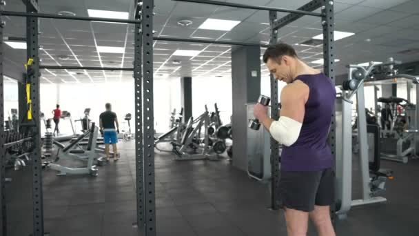 Muskulöser Mann mit verletztem Ellbogen-Training mit Kurzhantelgymnastik, Erholung, Kraft — Stockvideo
