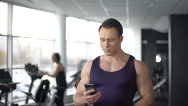 Culturista tomando selfie en el gimnasio y enviando por teléfono inteligente, tecnología moderna — Vídeo de stock