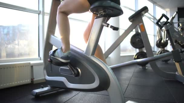 Female legs training on stationary bike, burning calories, cardio exercise — Stock Video