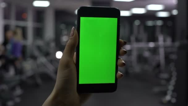 Жінка перевіряє кількість спалених калорій у додатку смартфона, зелений екран — стокове відео