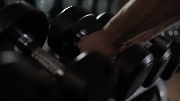 Nahaufnahme der Kurzhanteln Reihe, Bodybuilding-Trainer wählt Fitnessgeräte für Anfänger — Stockvideo