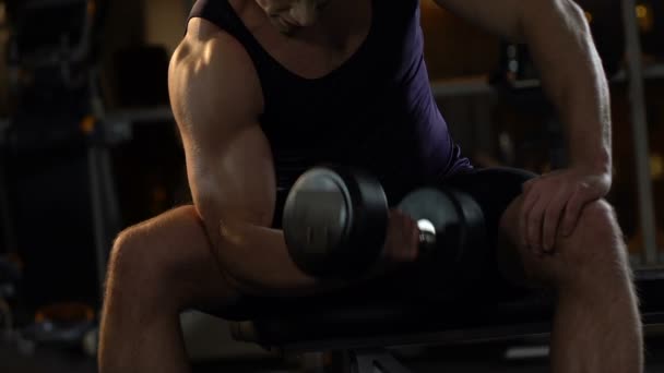 Bello bodybuilder che solleva manubri pesanti in palestra, allenamento attivo e sport — Video Stock