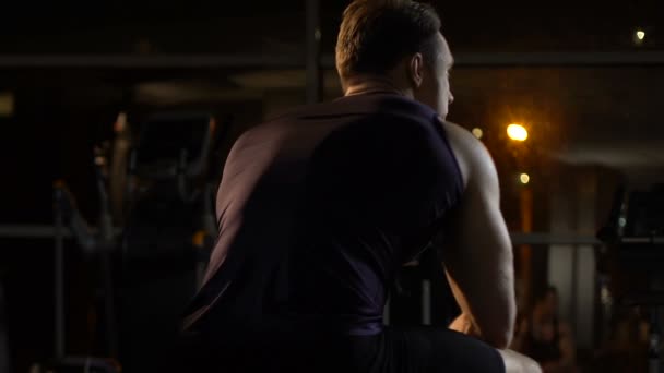 Sportowca przygnębiony siedzący w siłowni i myślenia o problemach, człowiek w rozpaczy — Wideo stockowe