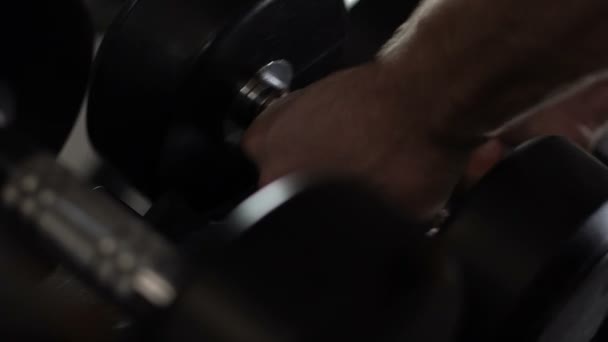 Main d'athlète prenant et mettant des haltères à la salle de gym, fitness et sport, entraînement — Video