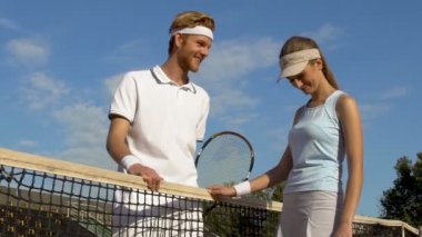 Güzel spor kadın tenis üzerinde net, konuşmandan flört utandım