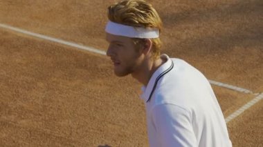 Yavaş hareket topu rakip için dönen turnuvada yarışan adam tenis oyuncusu