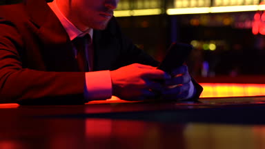 Sosyal ağlar kontrol tipik smartphone haber, barda oturan üzgün adam