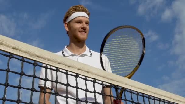 Щасливий усміхнений тенісист з ракеткою, здоровий спосіб життя, розкішний корт — стокове відео