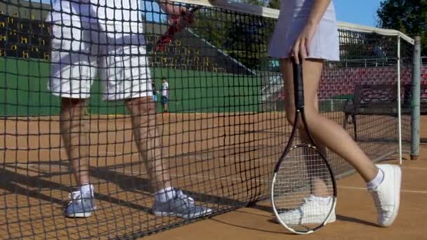 Guapo jugador de tenis coqueteando con la joven dama, invitación fecha en la cancha de tenis — Vídeos de Stock