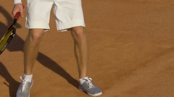 Mann in weißer Uniform läuft auf Tennisplatz, Rückhand während des Turniers — Stockvideo