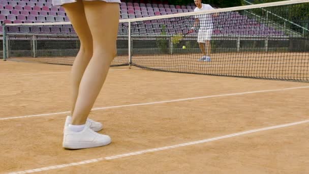 Pareja joven de la familia jugando al tenis fuera de la ciudad, ocio activo juntos, hobby — Vídeo de stock