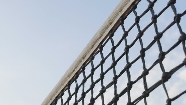 Тенісний м'яч потрапляє в мережу на фоні неба, гравець втрачає очко, спортивний турнір — стокове відео