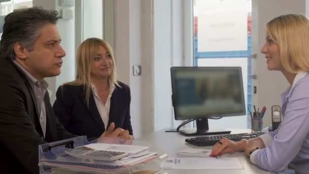 Dospělý pár sedí u realitní kanceláře a mluvit s manažerem, služby — Stock video