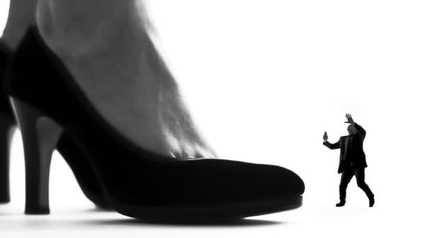 Женская нога на высоких каблуках сокрушает маленького мужчину, женское доминирование, силуэт — стоковое видео