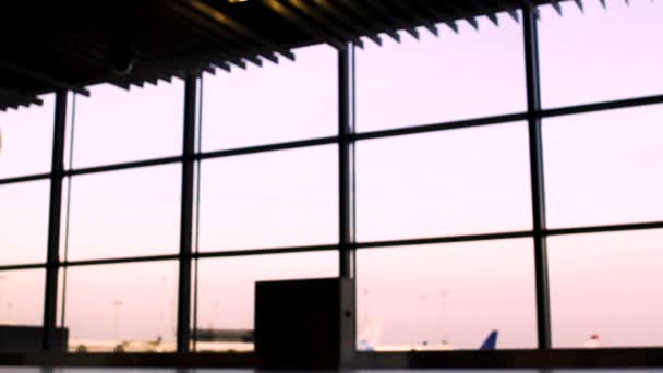 Siluetas de gente de negocios caminando en el aeropuerto, despegue en avión en el fondo — Vídeo de stock
