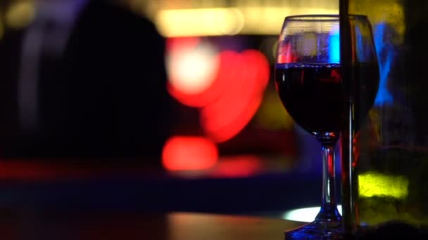 Garrafa de vinho vazia no fundo borrado com casal beijando, relações de uma noite — Vídeo de Stock