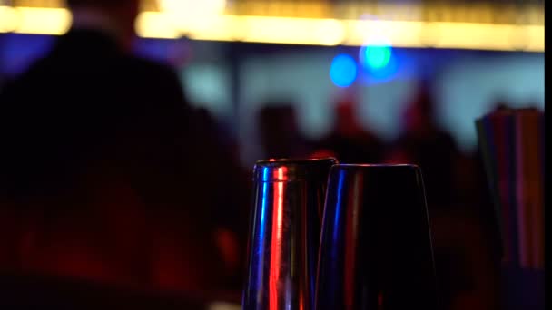 Бар-шакери на столі на танцювальному фоні людини, нічне життя насолода, алкоголь — стокове відео