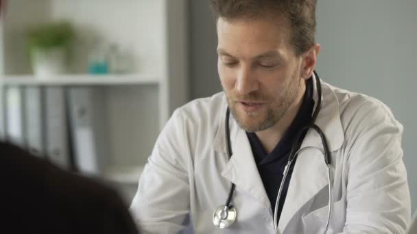 Добрий чоловік-терапевт консультує пацієнта, прописує ліки, охорона здоров'я — стокове відео