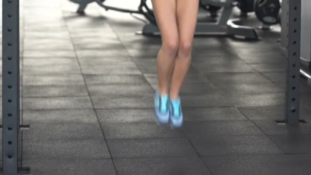 Тонка жінка стрибає через мотузку, займається фізичними вправами в спортзалі, дієтою та здоровим способом життя — стокове відео