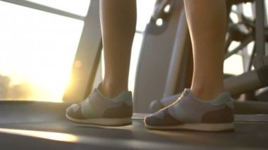 Pencere arka plan üzerinde spor olarak çalışma akşam yavaş yavaş koşu bandı üzerinde yürüyen kadın