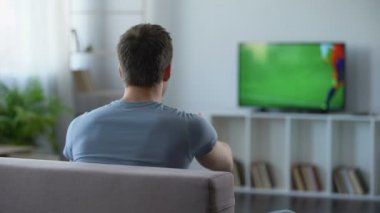 İzlerken futbol maç ev, eleştiren futbol takımı yenilgi için genç adam