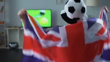 Büyük Britanya bayrağı, evde futbol oyun TV izlerken destekçisi tutan adam