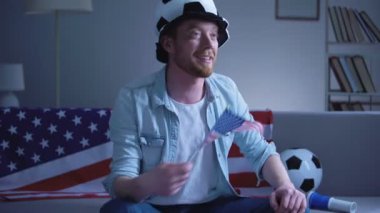 Amerikan futbol fan futbol evde televizyonda maçı izlerken dalgalanan ABD bayrağını