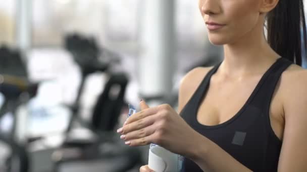 Mujer deportiva bebiendo agua dulce después del entrenamiento gimnasio, restaurando el equilibrio acuático — Vídeo de stock