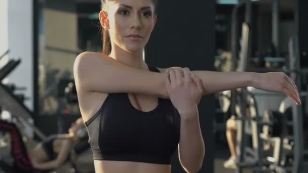 Frau wärmt sich vor Fitness-Routine im Fitnessstudio auf, Morgensonneneinstrahlung — Stockvideo