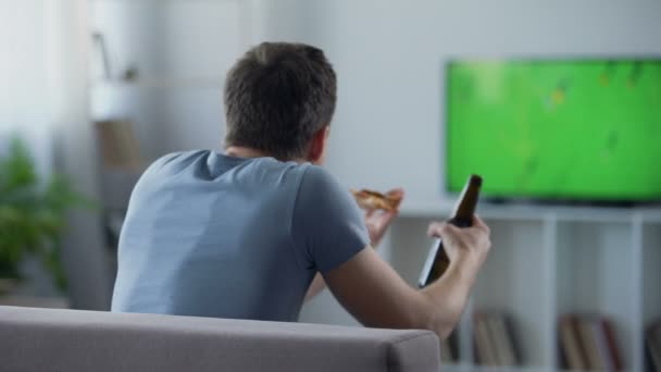 Бакалавр дивиться футбольний матч, що підтримує збірну, п'є пиво на дивані — стокове відео
