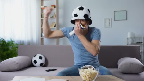 Apoiante de futebol em chapéu de fã assobiando em chifre regozijando-se com pênalti marcado — Vídeo de Stock
