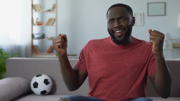 Hombre afroamericano bailando victoriosamente, celebrando la victoria del equipo de fútbol — Vídeos de Stock