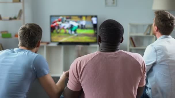 Хлопці активно вітають американську футбольну команду, люблять спорт, дозвілля вдома — стокове відео