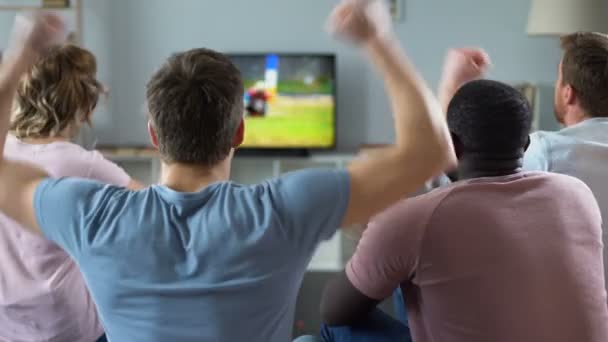 Πολυεθνική παρέα επευφημίες ομάδα ποδοσφαίρου, παρακολουθώντας αγώνα του στην τηλεόραση — Αρχείο Βίντεο