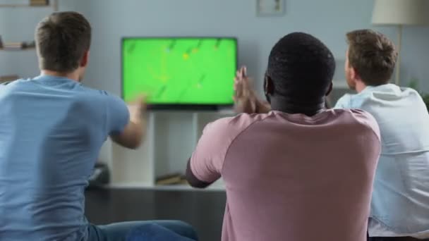 Mannelijke vrienden kijken naar voetbalwedstrijd op Tv, fans steunt nationale team — Stockvideo