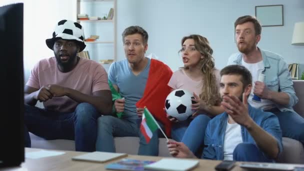 Tifosi italiani multirazziali seduti sul divano a guardare la partita, celebrando l'obiettivo — Video Stock