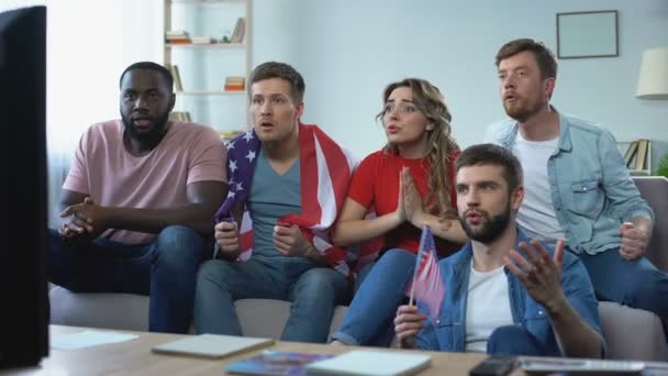 Fans estadounidenses multirraciales viendo el partido en casa, celebrando el gol del equipo — Vídeo de stock