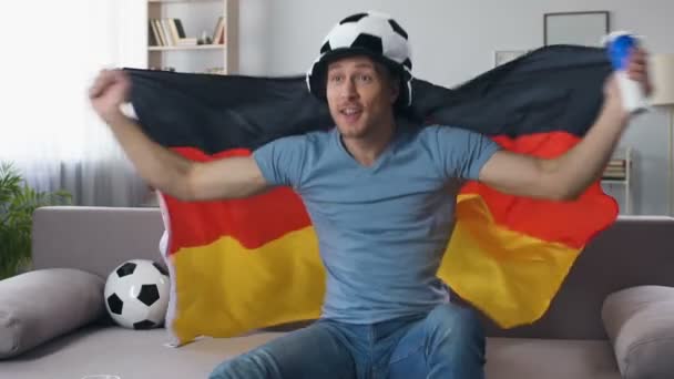 German football fan celebrating victory of national team, jumping with flag — Stock Video