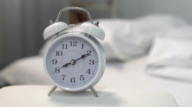 Yatak, zaman yönetimi, saat uyku yakınındaki gece masada beyaz çalar saat