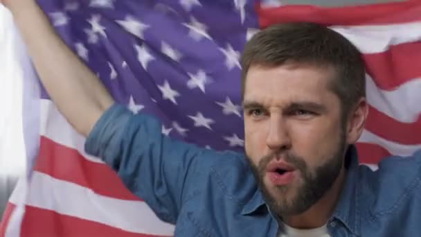 Человек, размахивающий американским флагом, празднующий победу кандидата в президенты, медлительный — стоковое видео