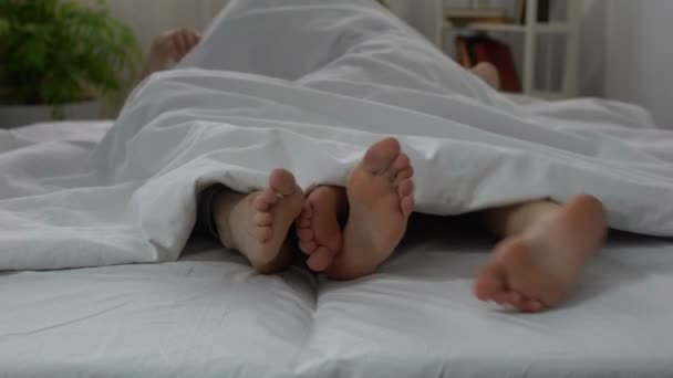 Pernas de marido e mulher fazendo amor na cama, casal relações íntimas, sexo — Vídeo de Stock