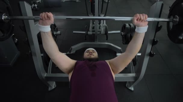 Hombre sudoroso levantando activamente la barra, bombeando sus músculos, estilo de vida saludable — Vídeo de stock