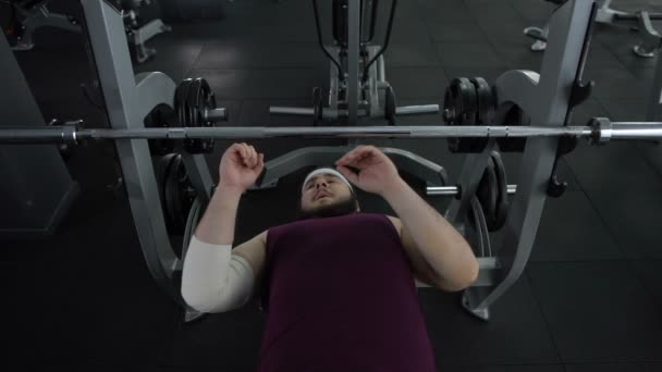 Man met elleboog bandage proberen omhoog barbell, sport trauma, herstel therapie — Stockvideo