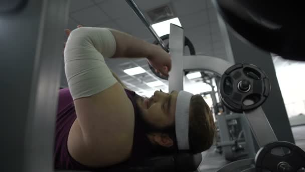 Skadade mannen i gym känsla skarp smärta i arm, lyfta skivstång på bänkpress — Stockvideo