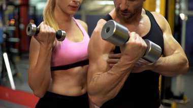 Eğitmen gösteren kadın stajyer nasıl egzersiz halter, sağlıklı bir yaşam tarzı ile yapılır