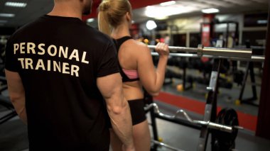 Genç bar halter yapıyor kadın onu antrenman ör kontrol altında egzersiz