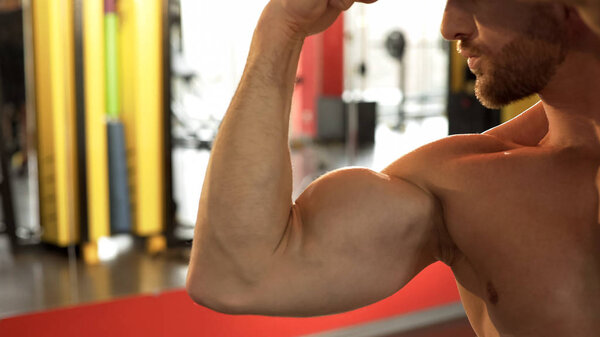 Muscleman doing bicep pose, demonstrating perfect athlete body, selfishness