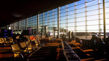 Havaalanı terminal, geniş güneşli bekleyen Öğretmenler odasında sandalye üzerinde oturan yolcular