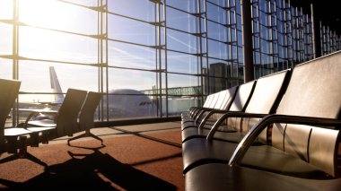Havaalanı terminal sabah yapraklara altında boş sandalye ile odada bekliyor, çelme takmak